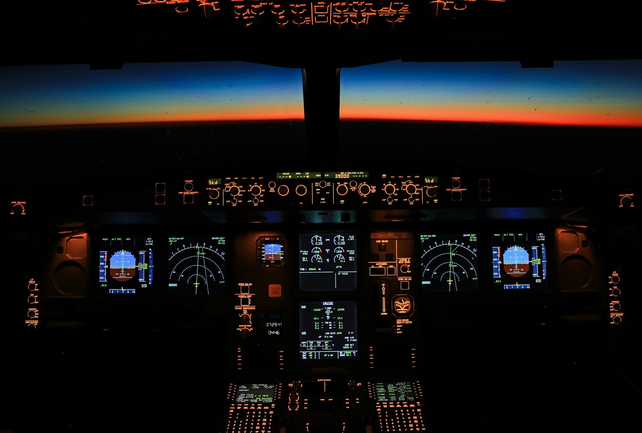 An airliner flight deck at dusk, with the horizon glowing ahead